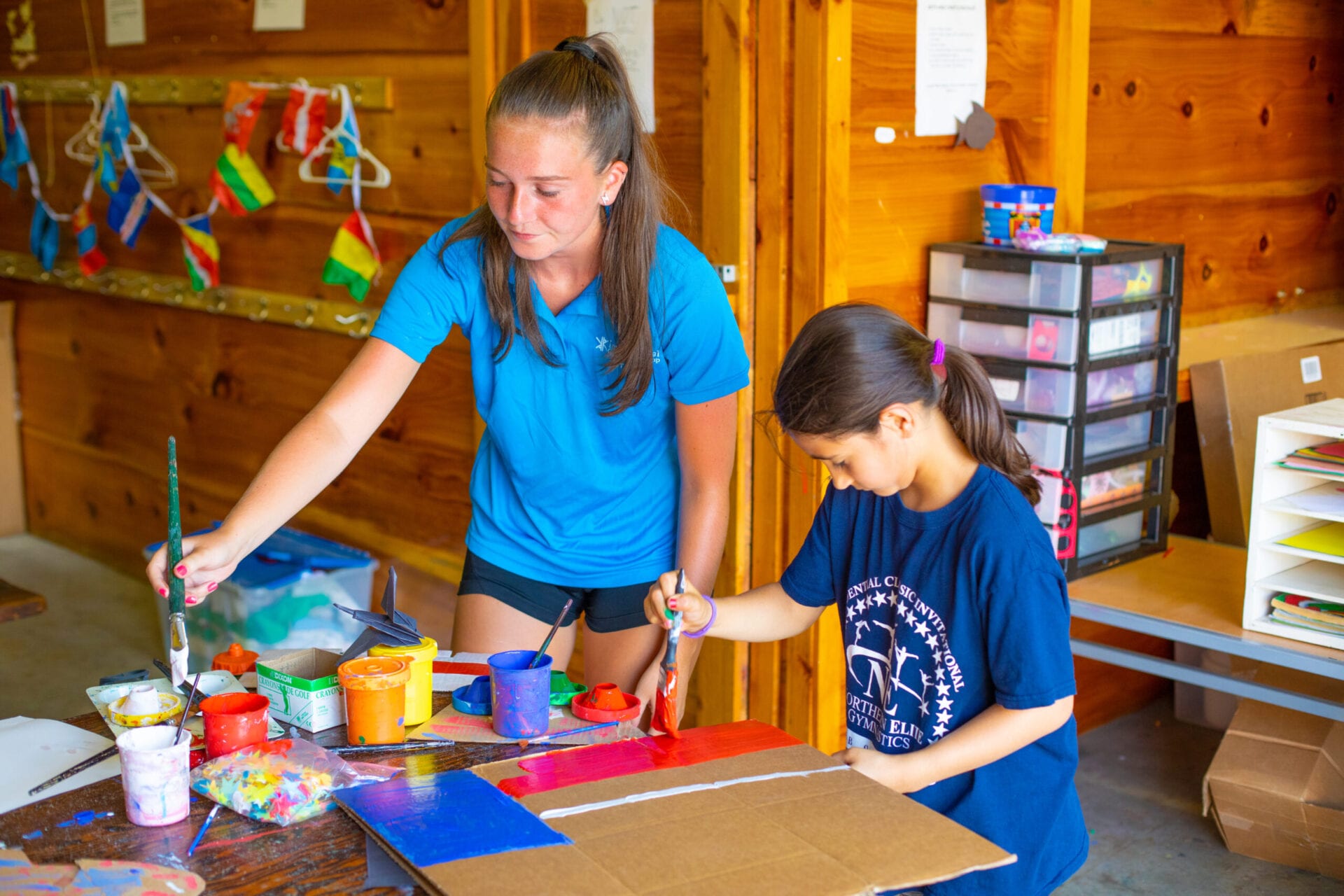 A woman and a boy engaged in arts and crafts at a table.