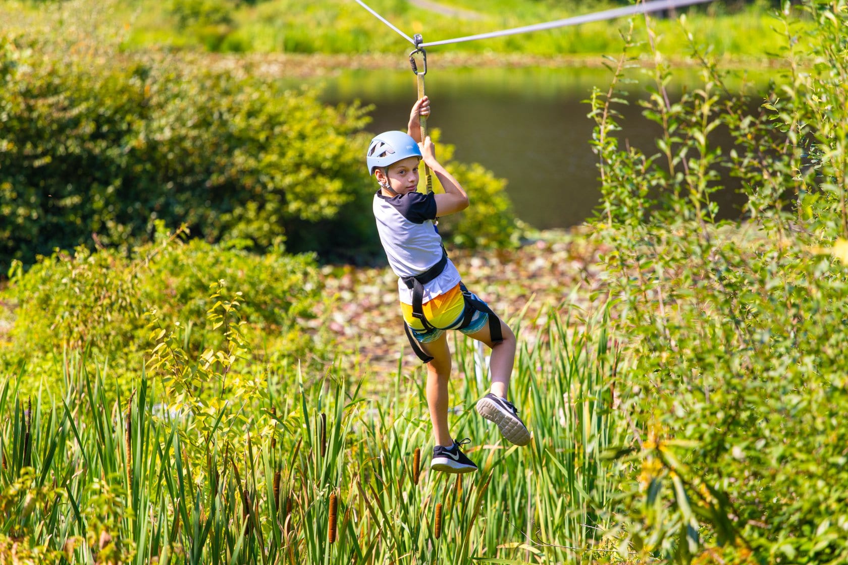 Child enjoying a zipline adventure in a lush outdoor setting.