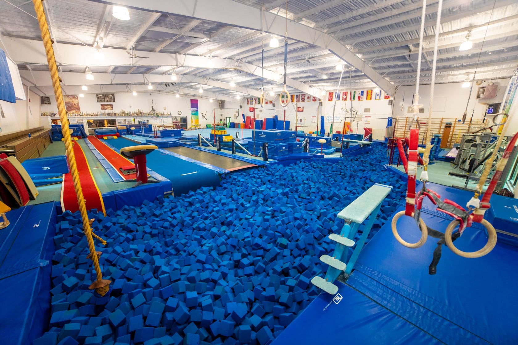 Indoor trampoline park with foam pit and obstacle course.